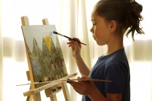 Picture of focused girl painting.